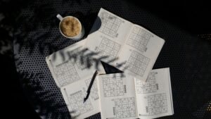 A calming flat lay of a Sudoku puzzle book with coffee, ideal for relaxation and focus.